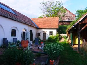 uma casa branca com um telhado vermelho e um quintal em Gästehaus Weinviertel - Niederösterreich em Siebenhirten