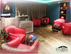 达卡The Raintree Dhaka - A Luxury collection Hotel的一间设有红色椅子和桌子的等候室