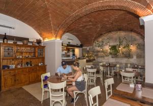 a man and woman sitting at a table in a restaurant at Hotel Amalfitana in Pisa