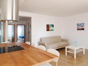 uma sala de estar com uma mesa e um sofá em Ocean Breeze Apartment em Estoril