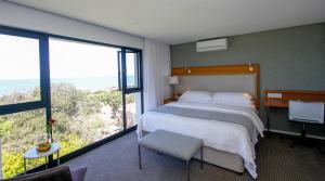 a bedroom with a large bed and a large window at Ocean Vista Boutique Guest House in Durban