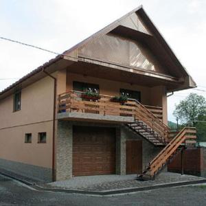 ein Haus mit einem Balkon und einer Treppe davor in der Unterkunft КОМФОРТ in Karpaty