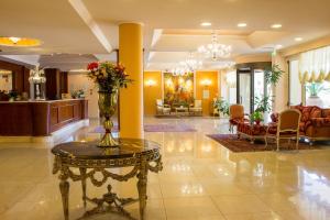 una hall con un tavolo con un vaso di fiori sopra di Semiramide Palace Hotel a Castellana Grotte