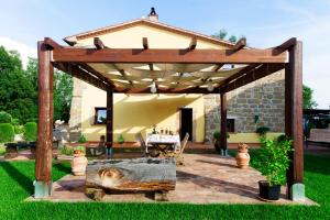 eine hölzerne Pergola mit einem Tisch im Hof in der Unterkunft FicOlivo in Pitigliano