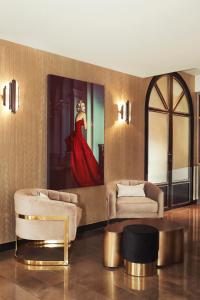 a living room with two couches and a painting of a woman at Hôtel le Derby Alma by Inwood Hotels in Paris