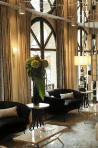 a living room with couches and a vase of flowers at Hôtel le Derby Alma by Inwood Hotels in Paris