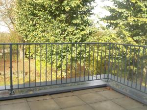 a metal railing on a balcony with trees in the background at LES JARDINS DE LA GRANGE in Rezonville