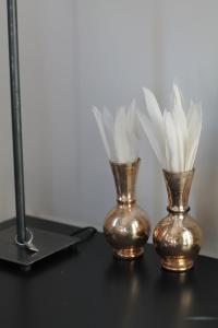 two gold vases sitting on a table with a lamp at Junior Suite The Backyard TBY 01 in Trier