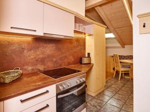 a kitchen with white cabinets and a stove at Gästehaus Renate in Längenfeld