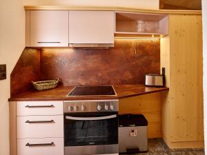 a kitchen with white cabinets and a stove top oven at Gästehaus Renate in Längenfeld