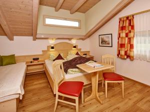 a bedroom with a bed and a table and chairs at Gästehaus Renate in Längenfeld