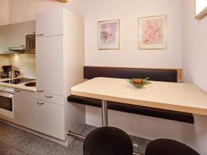 a small kitchen with a table and a refrigerator at Gästehaus Renate in Längenfeld