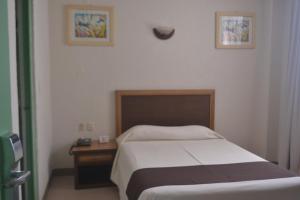 - une petite chambre avec un lit et une table de nuit dans l'établissement Hotel Plaza Independencia, à Villahermosa