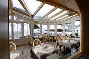 a dining room with tables and chairs and windows at Gasthof Burkert in Oetz