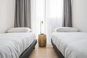 two beds sitting next to each other in a room at Skyline Flats Gent in Ghent