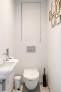 a white bathroom with a toilet and a sink at Skyline Flats Gent in Ghent