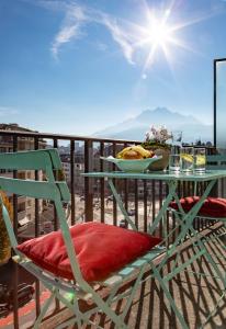 une table et une chaise vertes avec un bol de nourriture sur le balcon dans l'établissement Cascada Boutique Hotel, à Lucerne