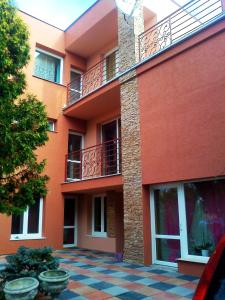 an orange building with a balcony and a courtyard at Penzión Vilka Podhájčanka in Podhájska