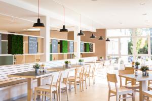 une rangée de tables et de chaises dans un restaurant dans l'établissement JUFA Hotel Graz City, à Graz