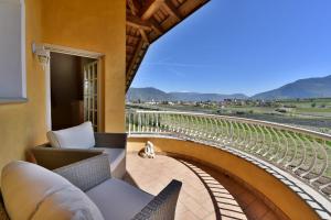 uma varanda com cadeiras e vista para uma vinha em Villa Raifer em Appiano sulla Strada del Vino