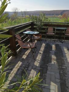 d'une terrasse avec une table et des chaises et une vue sur un champ. dans l'établissement Felsőréti Vendégház, à Demjén