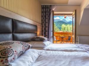 um quarto de hotel com uma cama e uma varanda em Hotel Zakopane Wellness & SPA ex Korona Tatr em Zakopane