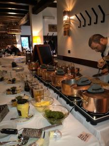 um homem a preparar comida numa fila de buffet com comida em La Locanda Del Grop em Tavagnacco