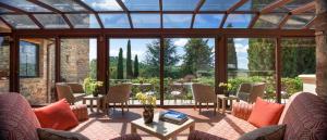 une véranda avec une grande verrerie, des chaises et des tables dans l'établissement Castello di Spaltenna Exclusive Resort & Spa, à Gaiole in Chianti