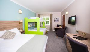 una camera d'albergo con letto e scrivania con sedia di Treacys West County Conference and Leisure Centre a Ennis