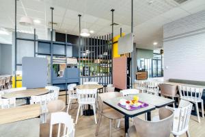 restaurację ze stołami i krzesłami oraz kawiarnię w obiekcie B&B HOTEL Paris Gennevilliers Asnières w mieście Gennevilliers