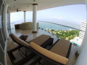 a balcony with a couch and a view of the ocean at Mondavi in Puerto Vallarta