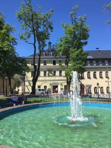 een fontein in een zwembad voor een gebouw bij Aparthotel Deutscher Kaiser Ferienwohnungen in Kurort Oberwiesenthal