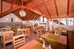 een restaurant met houten plafonds en tafels en stoelen bij Hotel Pension Fent in Bad Füssing