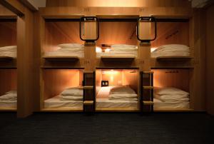 a room with four bunk beds with lights on them at TSUKIMI HOTEL in Kyoto