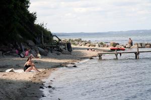 una donna in costume da bagno seduta su una spiaggia di Dancamps Trelde Naes (Camp Site) a Fredericia