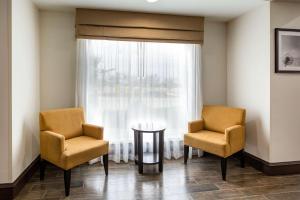 a waiting room with two chairs and a table and a window at Sleep Inn & Suites - Bryan in Bryan