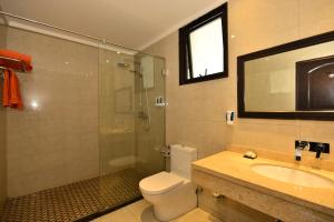 e bagno con doccia, servizi igienici e lavandino. di Baobab Holiday Resort a Bamburi