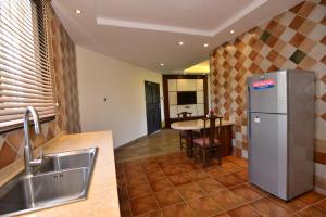 una cucina con frigorifero in acciaio inossidabile e tavolo di Baobab Holiday Resort a Bamburi