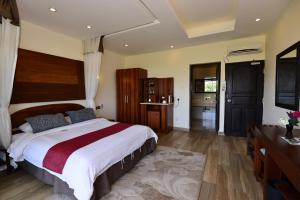 una camera con un grande letto e un bagno di Baobab Holiday Resort a Bamburi