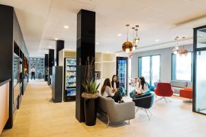 drie vrouwen in stoelen in een wachtkamer bij B&B HOTEL Zürich Airport in Rümlang