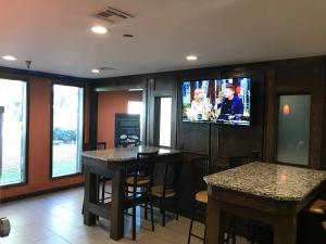 ein Restaurant mit zwei Tischen und einem TV an der Wand in der Unterkunft Super 8 by Wyndham Fayetteville in Fayetteville