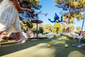 una mujer jugando al minigolf en un parque temático en Zaton Holiday Resort Mobile Homes, en Nin