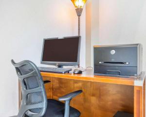 escritorio con ordenador, monitor y silla en Comfort Inn & Suites Patriots Point, en Charleston