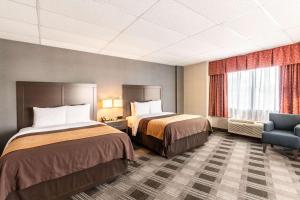 ein Hotelzimmer mit 2 Betten und einem Stuhl in der Unterkunft Comfort Inn Ballston in Arlington