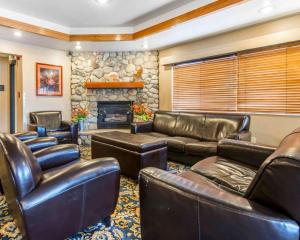 a living room with leather furniture and a stone fireplace at Comfort Inn Salida in Salida