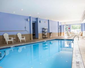 WethersfieldにあるComfort Inn Wethersfield - Hartfordのスイミングプール(椅子、テーブル付)