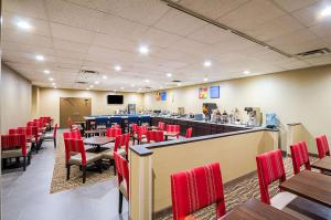 un comedor con sillas rojas y un bar en Comfort Inn Downtown, en Cleveland