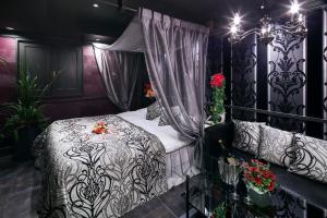 a bedroom with a black and white bed with flowers on it at Restay Okayama (Adult Only) in Okayama