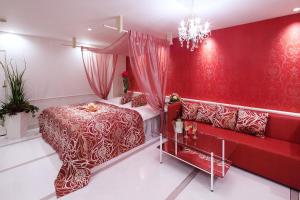 a red bedroom with a bed and a couch at Restay Okayama (Adult Only) in Okayama