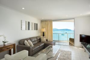 a living room with a couch and a television at at Marina Shores in Airlie Beach